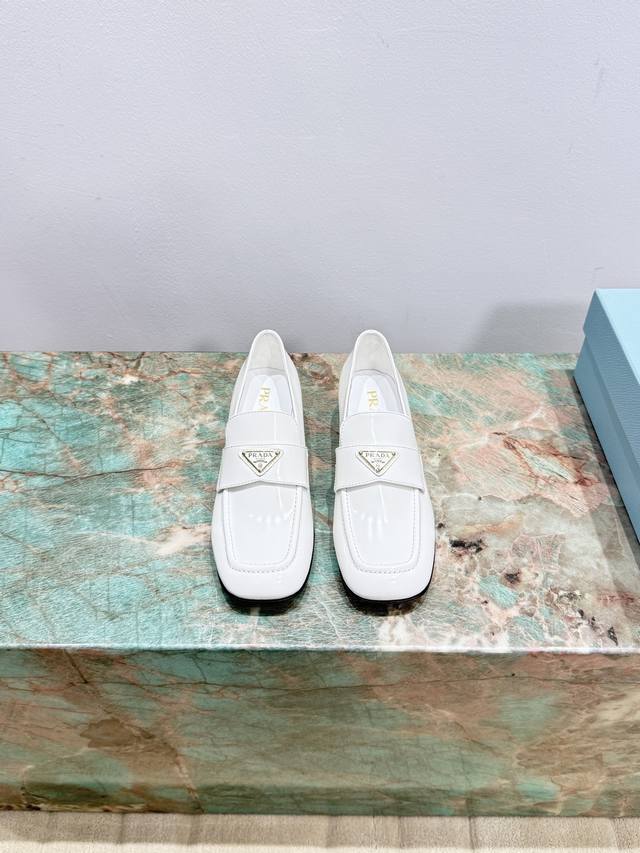 Prada's new triangle-shaped block-heeled loafers This exquisite shiny leather lo
