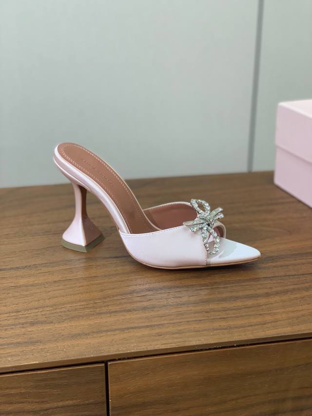 Amina Muaddi bow-knot diamond-buckle slippers. Elegant style creates a unique fe