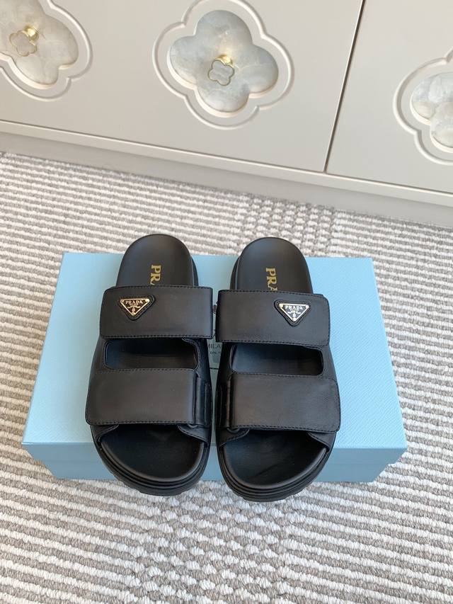 Prada's new triangle logo platform slippers with Velcro fastening. These sporty