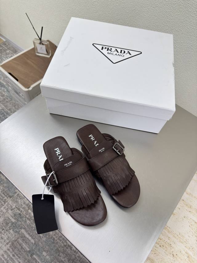 Vintage tasseled Prada flip-flops. Flat-soled design in brown. Simple design wit