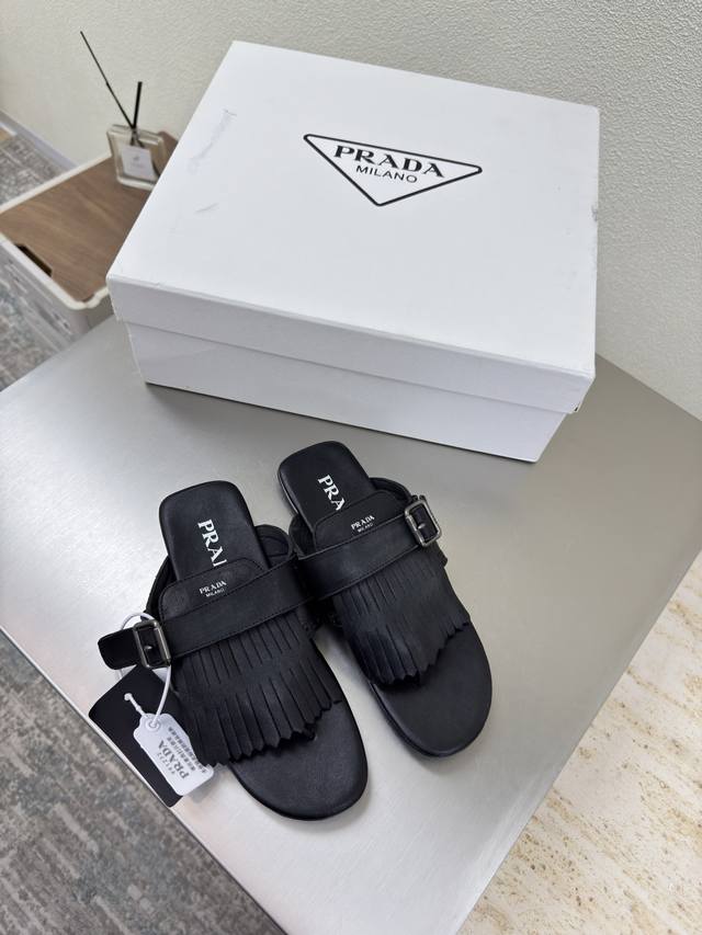 Vintage tasseled Prada flip-flops. Black flat-soled design with a minimalist des
