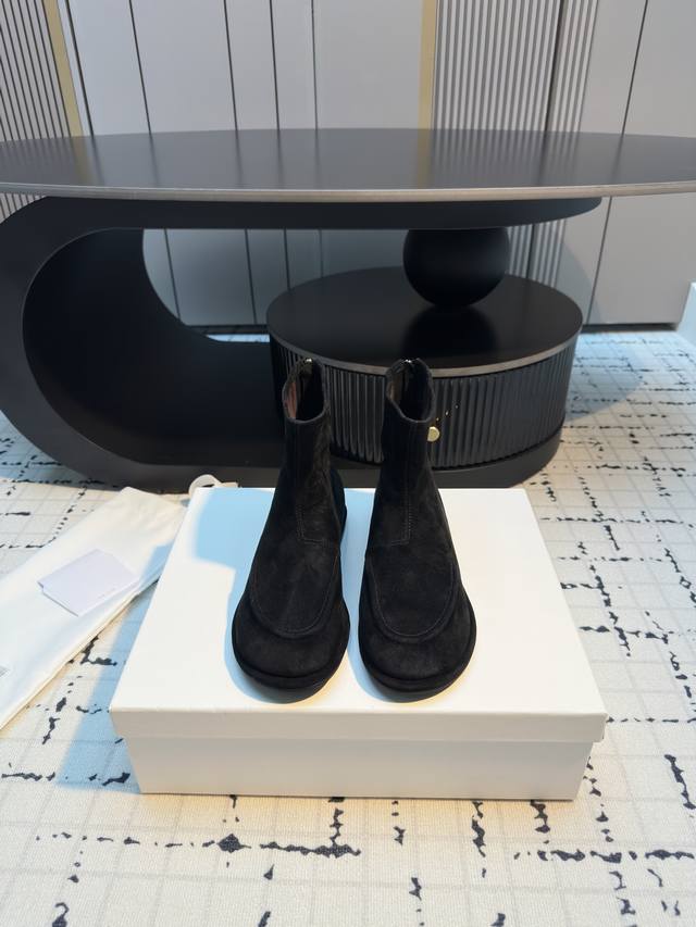 The Row's classic retro round-toe flat ankle boots. Their minimalist design evok