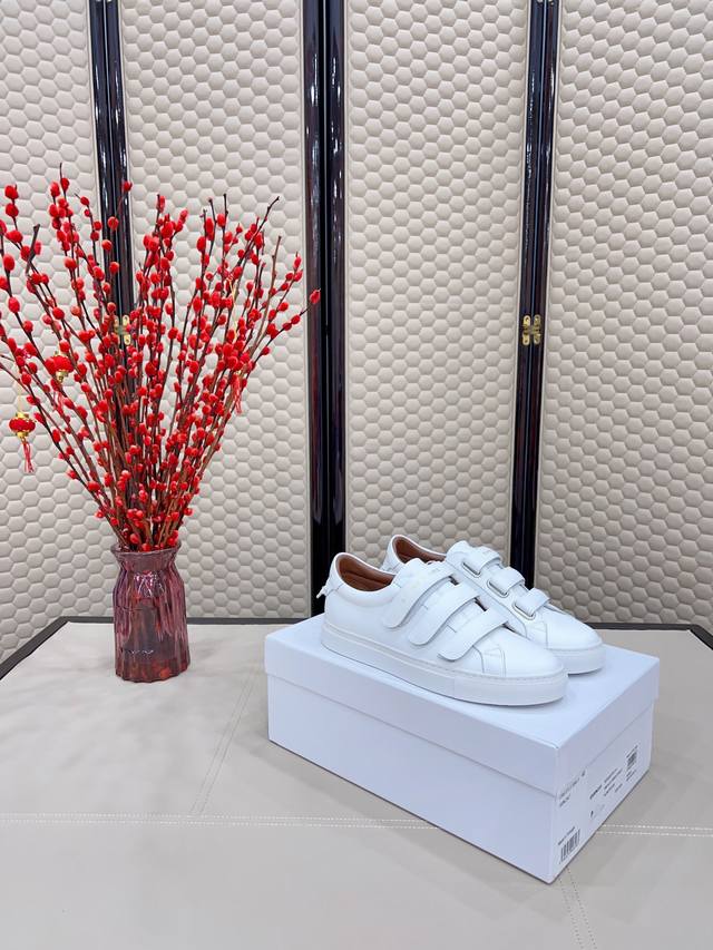 Certified white sneakers , featuring a silver metal buckle with a logo on the