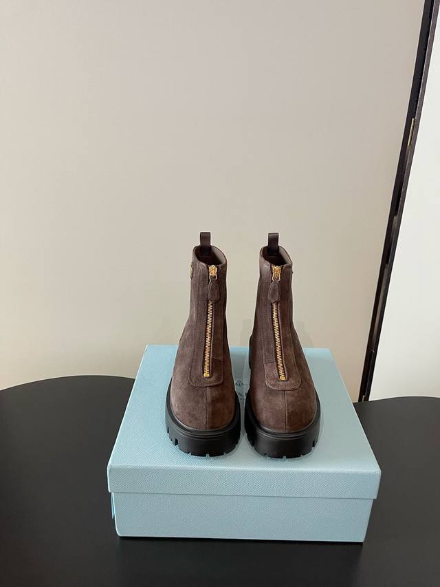 Prada's latest thick-soled, front-zippered ankle boots ( ) are embellished with