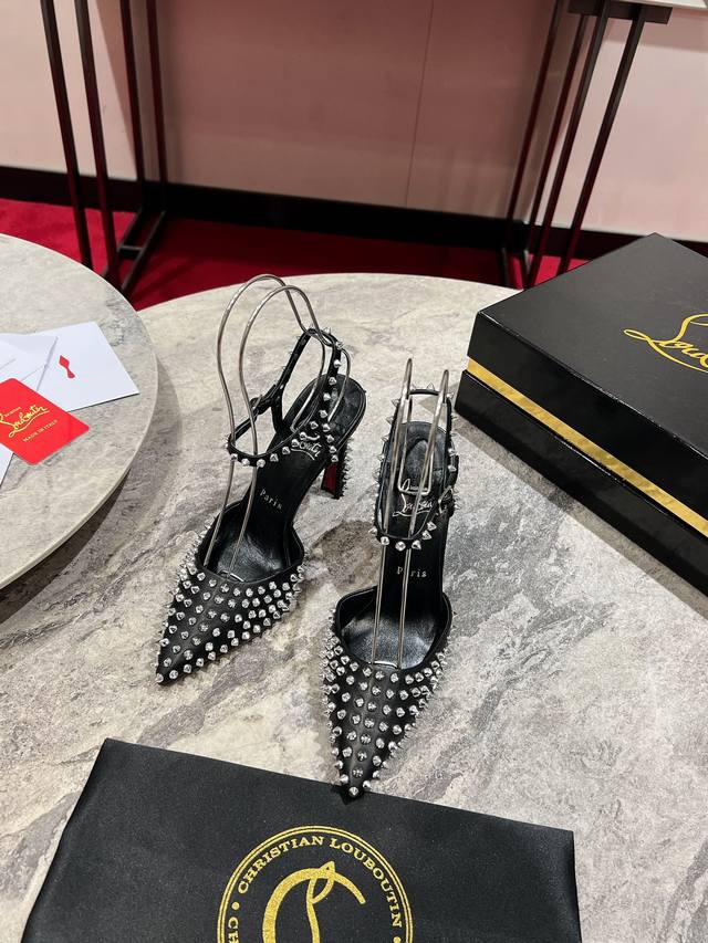 Banana-shaped heel with full studs and open back. Maison Christian Louboutin's C