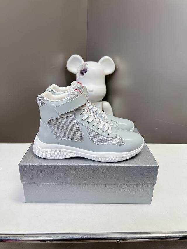 Prada premium high-top sneakers. Features include an imported flyknit upper with