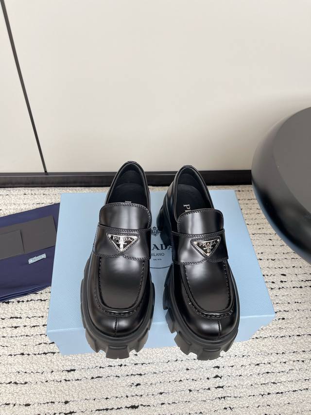 Dongguan-made Prada retro loafers with a triangle logo. The triangle logo metal