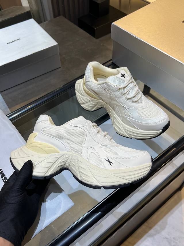 Smfk brand chunky sneakers feature a black and white color-blocked upper with a